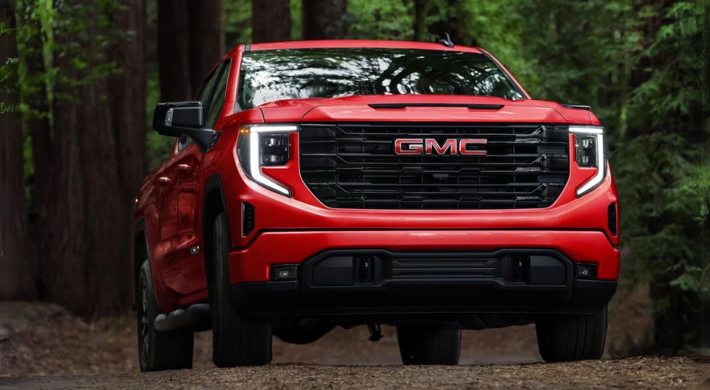 Red 2025 GMC Sierra 1500 for sale driving on a trail