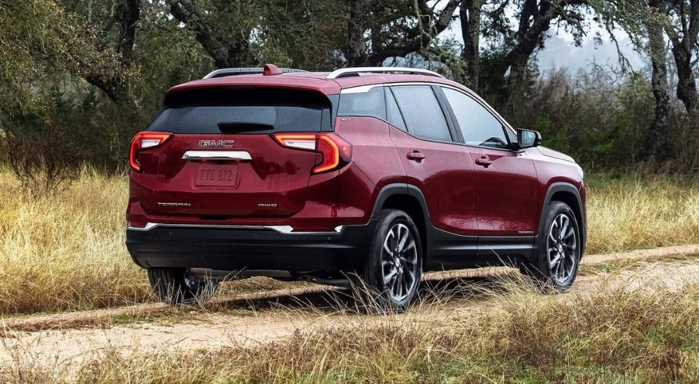 Red 2022 GMC Terrain driving to view a used GMC for sale