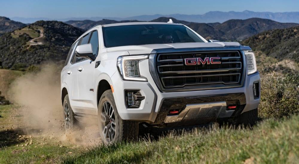 White 2023 GMC Yukon AT4 driving off-road
