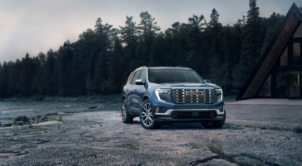 Blue 2024 GMC Acadia Denali parked off-road