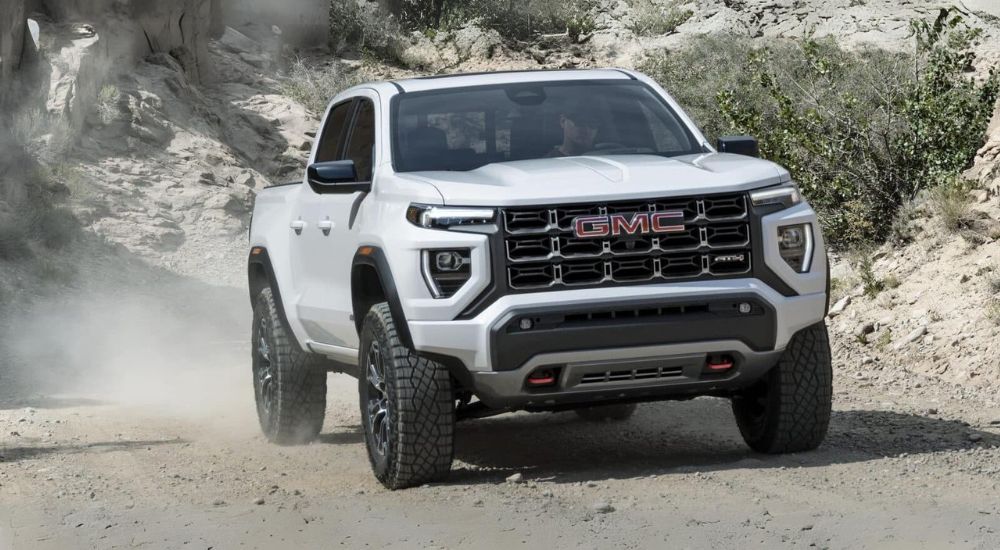 White 2025 GMC Canyon AT4 driving on a trail