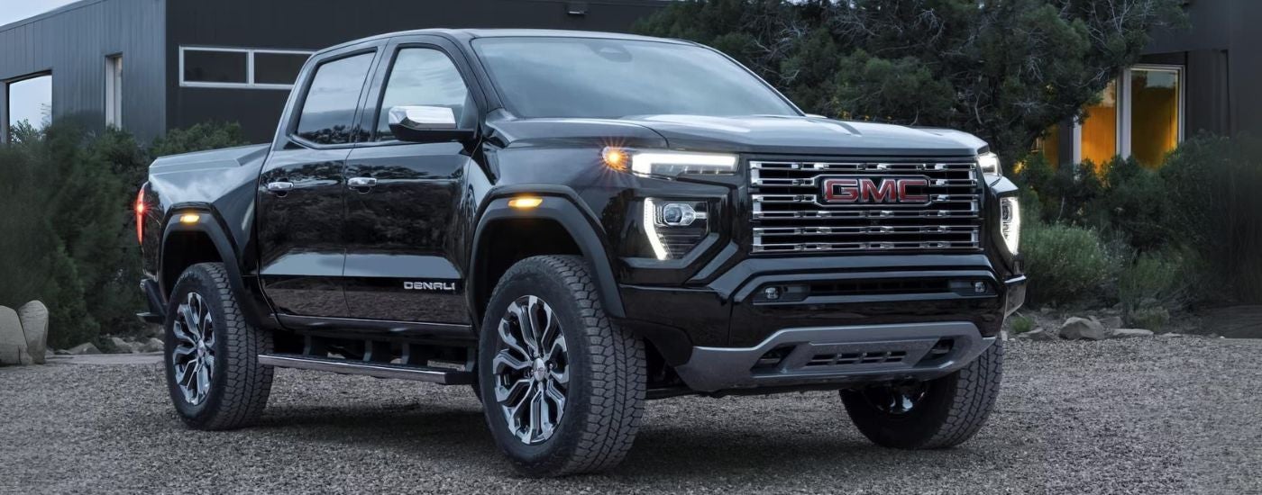A black 2026 GMC Canyon Denali parked near a house.
