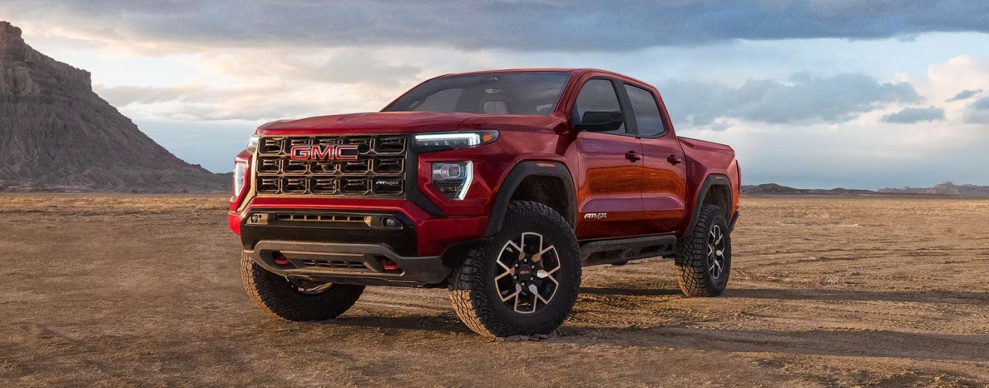 A red 2026 GMC Canyon AT4X parked off-road.
