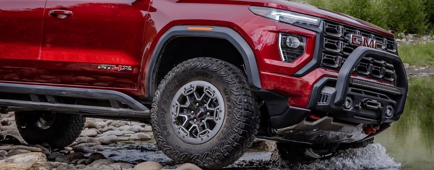 Close-up of the front passenger side of a red 2026 GMC Canyon AT4X.