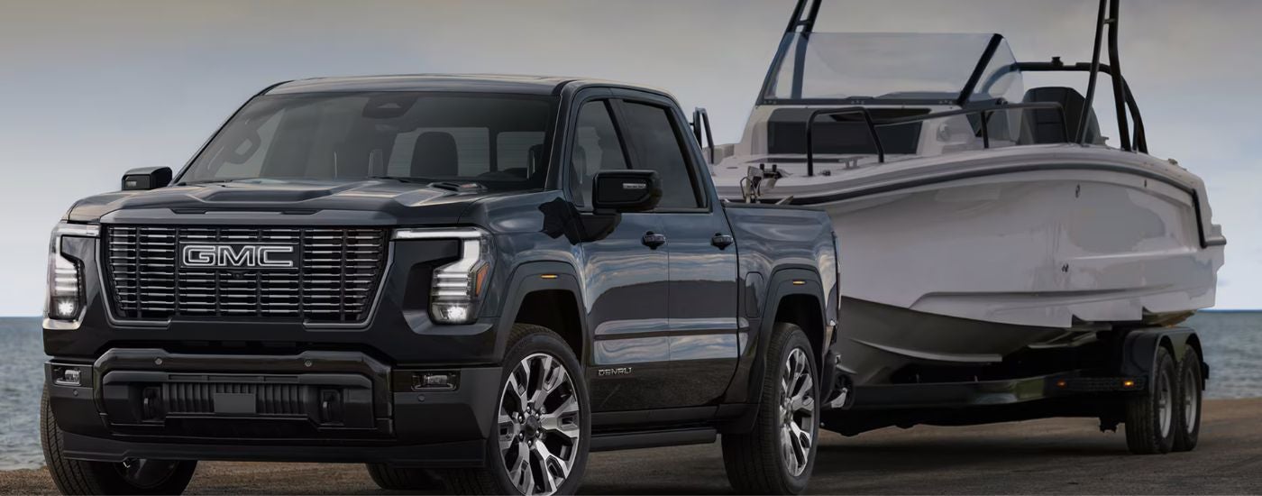 A black 2027 GMC Sierra 1500 towing a boat.