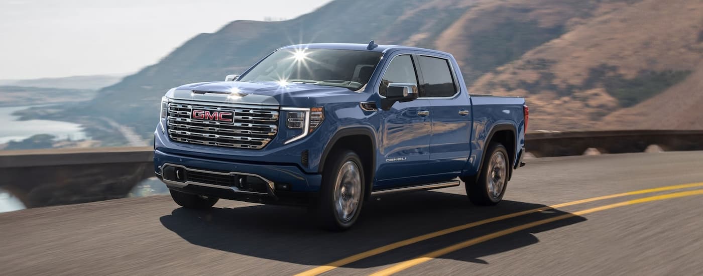 Blue 2025 GMC Sierra 1500 for sale near Madisonville driving on a winding road