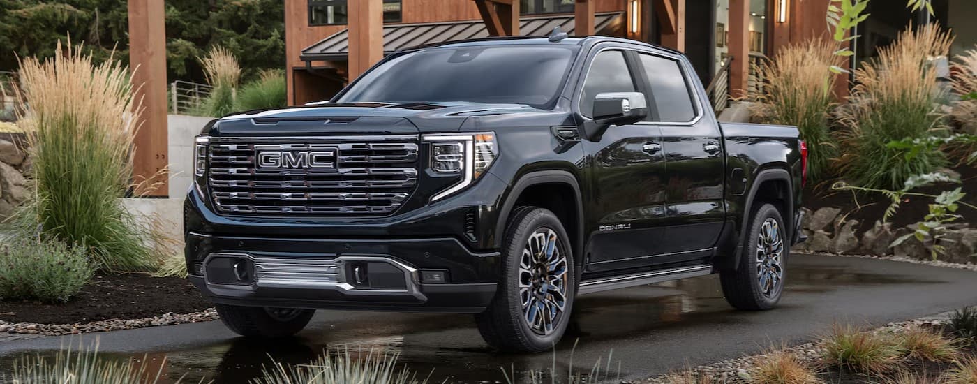 A black 2025 GMC Sierra 1500 Denali parked on a driveway.